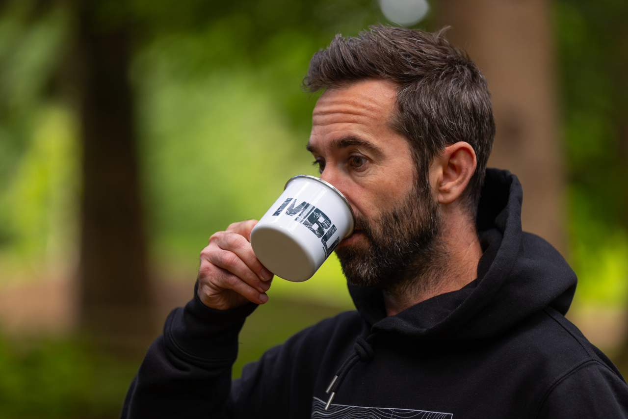 Rider drinking from an MBUK Enamel Mug in the woods