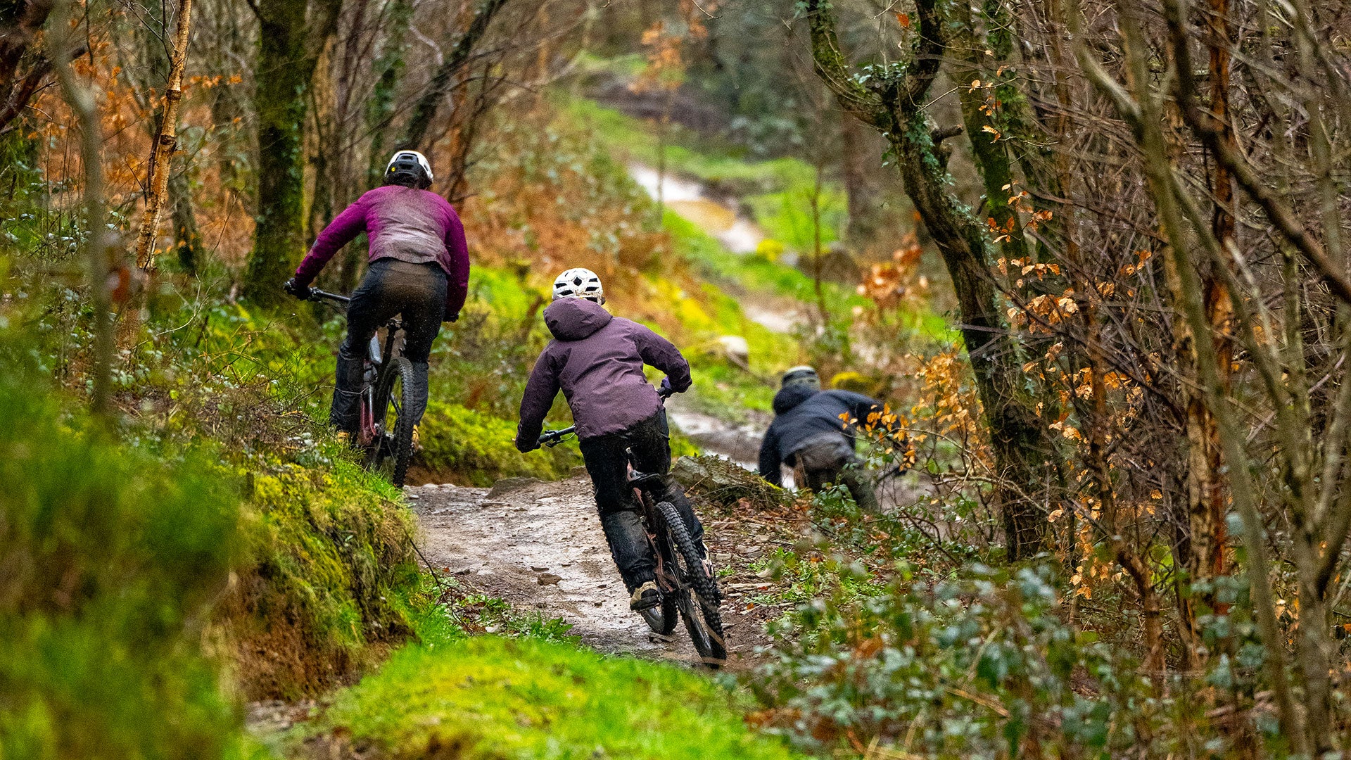 Three members of the MBUK team riding along a trail